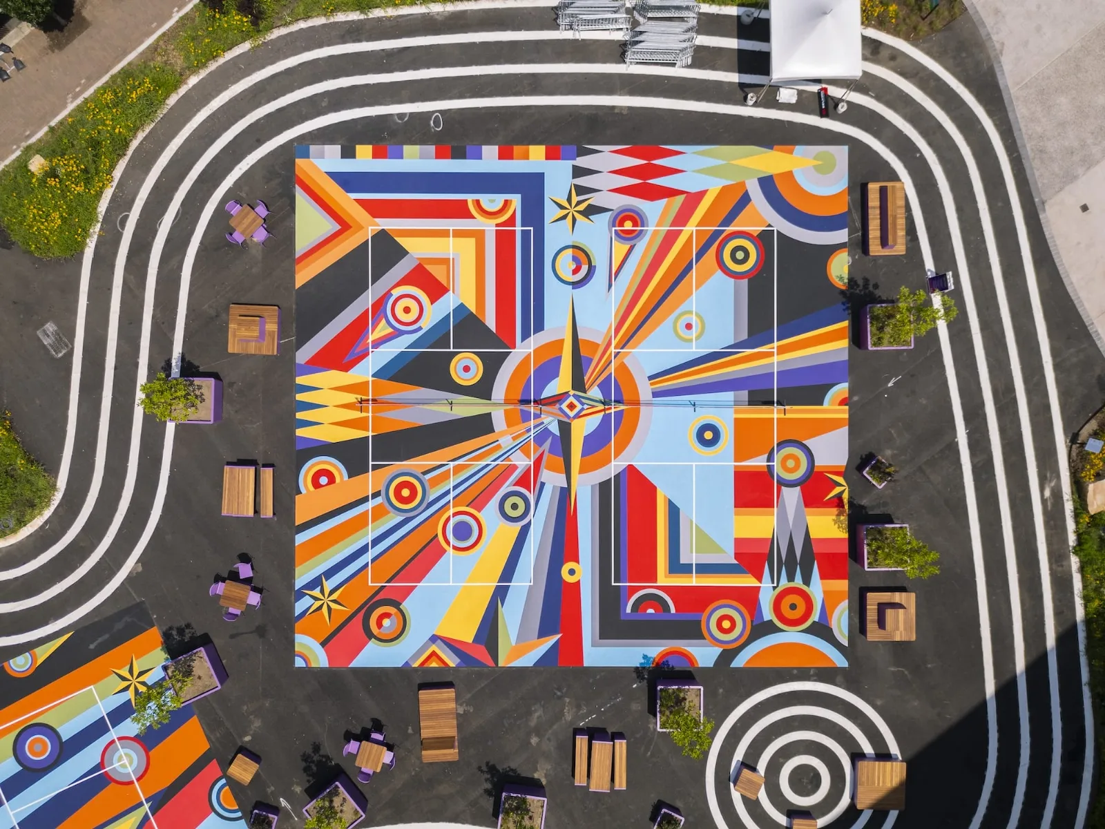 Canchas de pickleball pintadas con murales geométricos abstractos en tonos vibrantes de rosa, azul y amarillo
